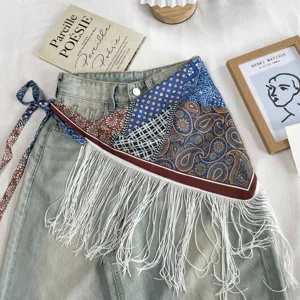 Detailed shot of ethnic vintage printed triangular scarf with white fringe and side tie design.