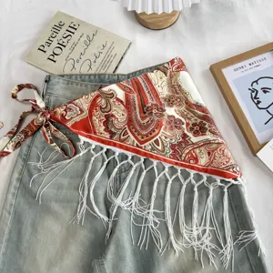 Detailed view of ethnic paisley print triangle scarf with fringe tassels for stylish layering skirt.