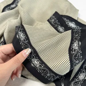 Close-up detail of vintage polka dot triangle scarf with ornate black border design.