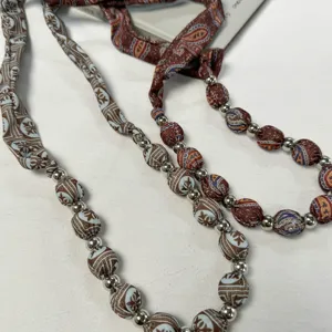 Detail shot of vintage floral fabric beaded waist chain and hair scarf accessory, retro design.