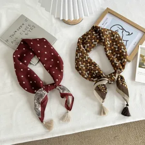 Detail view of women's small square scarf with polka dots, geometric pattern and tassel fringe.