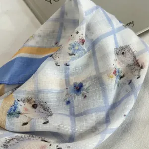 Primo piano dettagliato di una graziosa sciarpa a quadri blu con motivi di ricci e fiori delicati.