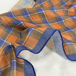 Foulard en soie à carreaux orange et bleu, accessoire élégant pour des tenues stylées.