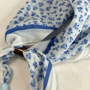 Sciarpa in seta perlata con stampa floreale blu pastorale, dettaglio foulard triangolare.