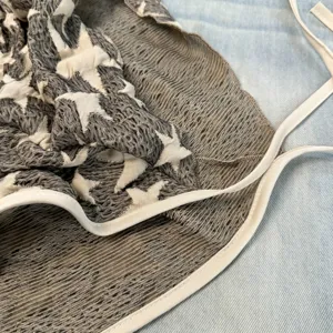 Detailopname van retro sterren mesh kant laagskirt stof met contrasterende randen en bandjes.