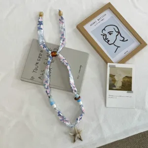 Floral silk scarf necklace detail, starfish pendant and beads, elegant summer neckwear.