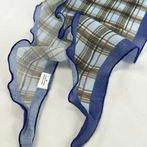 Détail de foulard triangulaire à carreaux bleu et brun, accessoire de mode stylé.