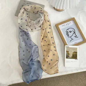 Detail view of the gradient color long silk scarf featuring cute heart prints and chic style.