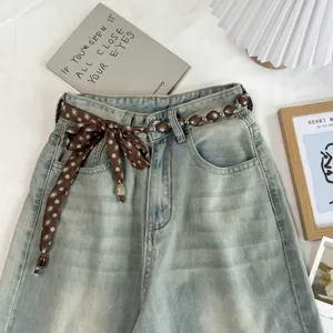 Vintage floral beaded waist chain and scarf accessory styled with blue denim jeans.