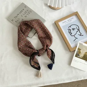 Details of a retro geometric medallion print small square scarf featuring elegant tassels.