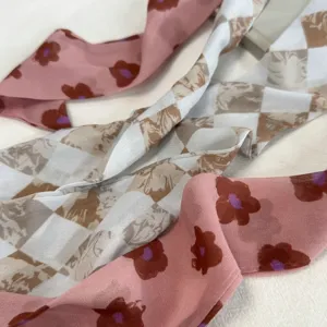Prachtige detailopnamen van artistieke zijden sjaals met bloemen- en ruitmotief voor nek.