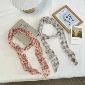 Gedetailleerd overzicht van lange zijden sjaals met bloemen- en ruitprint voor nek of haar.