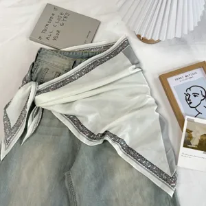 Detailed view of a retro color-blocked triangular scarf styled on denim for daily wear.
