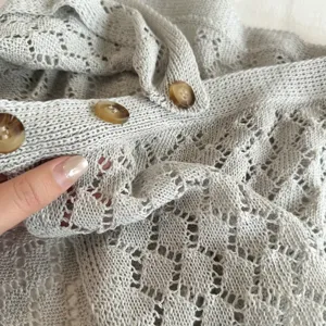 Grijze gehaakte rokverlenging detailopname, stijlvolle modieuze gelaagde taille-accessoire.