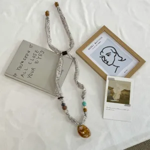 Retro paisley zijde sjaal ketting met kralen en hanger, stijlvol accessoire detail.
