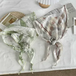 Detailopname van elegante florale en gestreepte driehoekige sjaals van zachte, lichte stof.