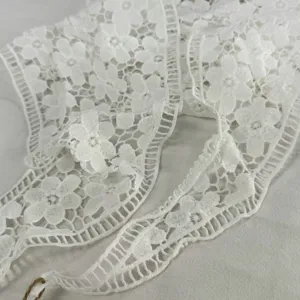 Weißes Blumen-Spitzenborte Detail-Nahaufnahme, elegante hohle Stofftextur zum Nähen.