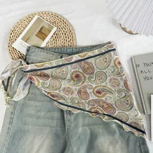 Detailopname van een retro paisley patroon driehoekige sjaal gestyled met denim jeans.