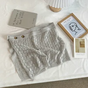 Witte opengewerkte gebreide rok in Koreaanse stijl detail met delicate textuur en knopen.