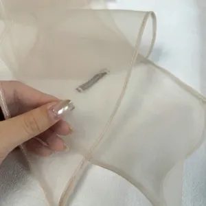 Détail d'écharpe longue en tissu mousseline transparente, texture délicate et respirante.