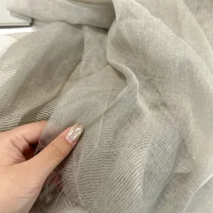 Gros plan de la texture légère du foulard en tulles transparente et détails doux.