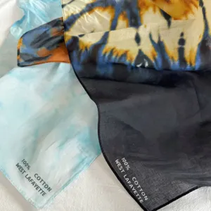 Primo piano sul dettaglio del fazzoletto in cotone batik con trama morbida e motivo vivace.