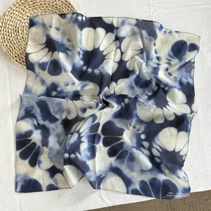 Vista dettagliata di una sciarpa quadrata in cotone blu e bianco con fantasia tie-dye estiva.