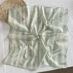 Vista dettagliata di un elegante foulard quadrato tie-dye verde chiaro in 100% cotone estivo.