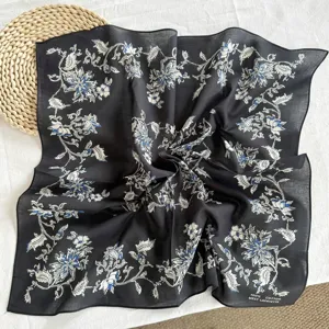 Detail view of the black and white cotton floral square scarf, showing fabric texture and print.