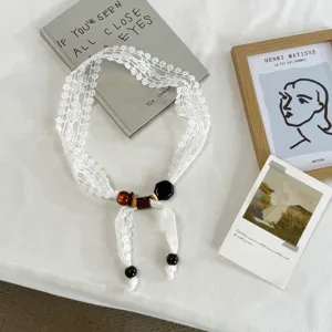 White lace scarf necklace detail view featuring elegant beads for spring summer fashion styling.