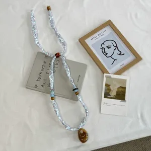 Detailed view of fashionable printed fabric necklace scarf, perfect for stylish shirt matching.