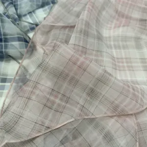 Detalle refinado del pañuelo de seda largo y ligero, con un elegante diseño de cuadros.