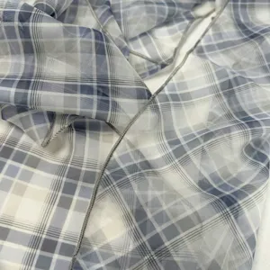Detalle de la hermosa bufanda a cuadros azul con tela ligera y bordes cosidos finamente.