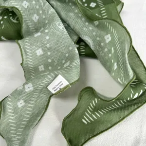 Detailed view of the green floral printed lettuce edge scarf, showing fabric texture and design.