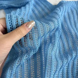 Gros plan sur le tissu tricoté en soie glacée bleu clair avec texture de maille respirante.