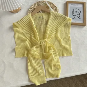 Détail de châle en tricot ajouré jaune, texture en soie de glace et design de nouage avant.