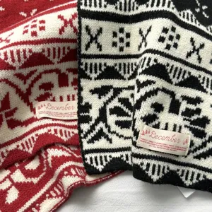 Close-up detail of winter Christmas jacquard knitted scarf with brand tag, cozy and warm.