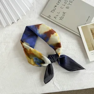 Vista ravvicinata di un bellissimo foulard quadrato in cotone tie-dye, elegantemente annodato.