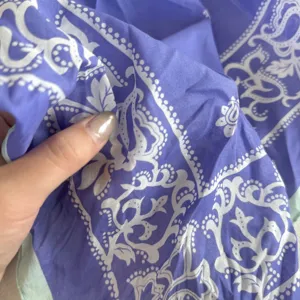 Gedetailleerde close-up van de paarse katoenen paisley hoofddoek met fijne textuur.