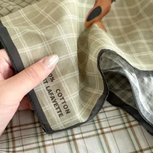 Detailed closeup photo of a vintage plaid cotton square scarf featuring cute dog print.