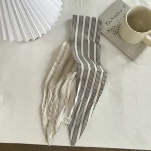 Primo piano dettagliato della sciarpa e della fascia a righe in cotone su uno sfondo bianco.