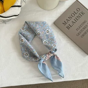 Close-up detail of a charming blue floral print small square scarf for stylish daily neck wear.