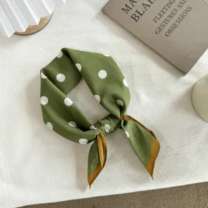 Gros plan détaillé d'un foulard carré à pois vert vintage, style écharpe élégant.