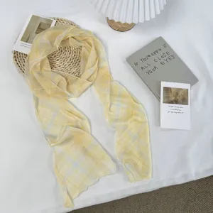Gedetailleerd uitzicht op een retro gele geruite zijden sjaal, vintage stijl accessoire.