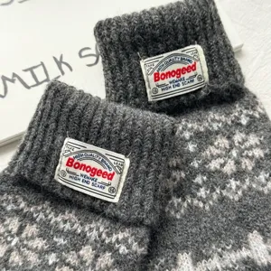 Grey Nordic pattern knitwear detail close-up showing texture and vintage woven brand tag.