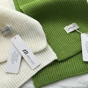 Gros plan detaille d'une echarpe en tricot confortable avec etiquette, cache-cou doux.