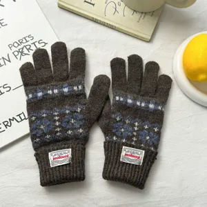 Brown knit winter gloves with blue and white Nordic pattern, ribbed cuff and label detail.