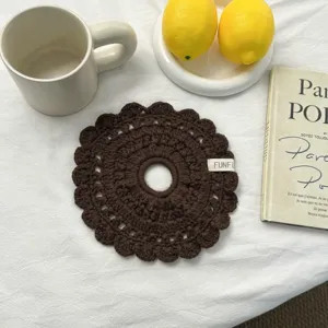 Gros plan détaillé de l'écharpe ou chouchou marron foncé en crochet au motif ajouré.