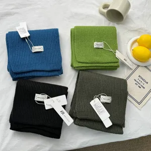 Gros plan détaillé de doux écharpes d'hiver en tricot côtelé aux quatre coloris unis.