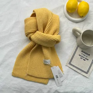 Detail d'echarpe en tricot jaune montrant texture de laine douce et design d'hiver.